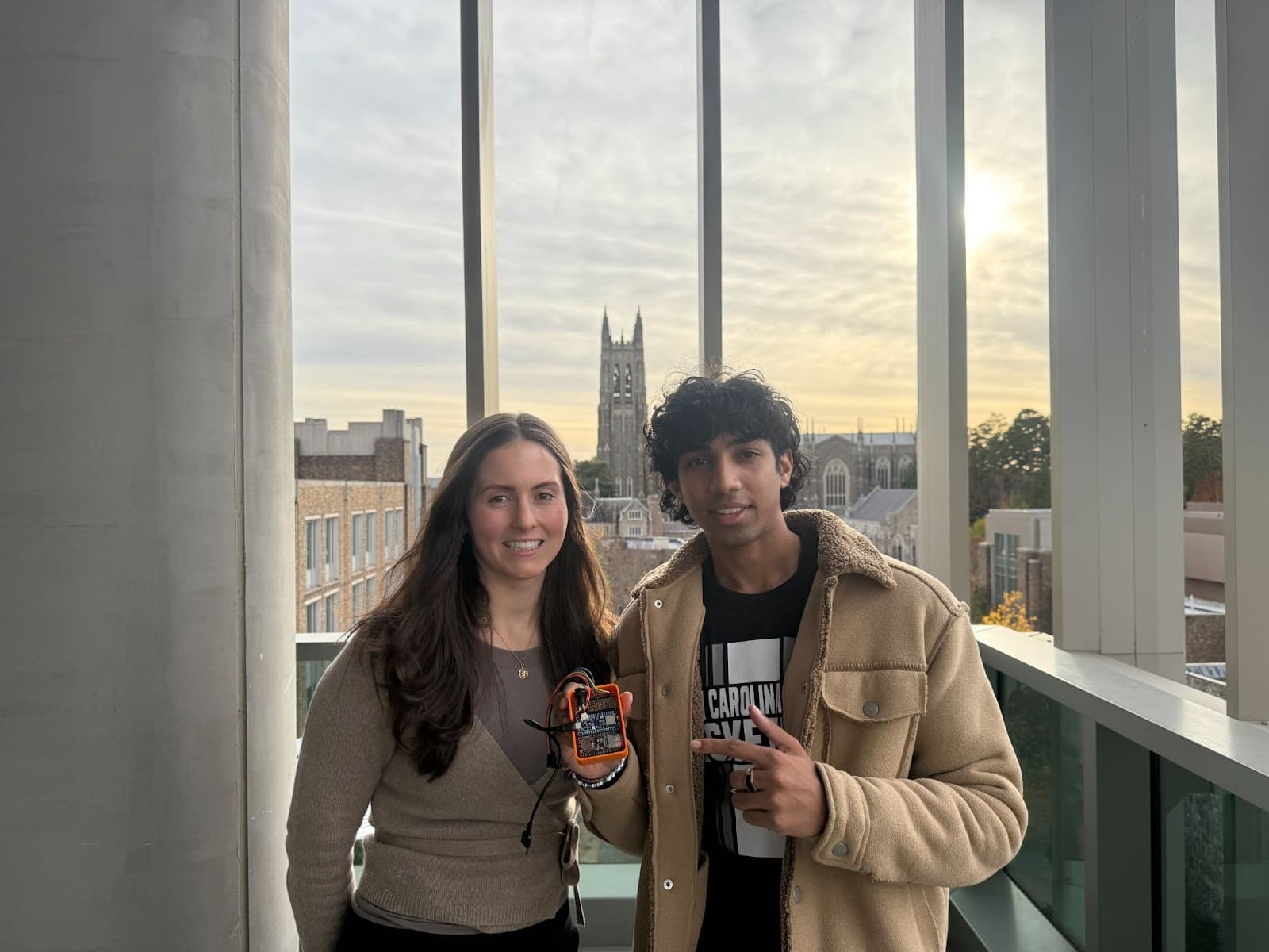 Lauren Lederer and Hadi Abdul holding a VitalWave wearable device at Duke